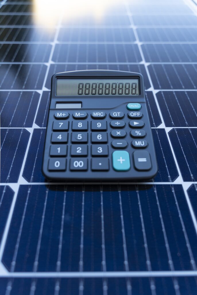 Energy saving concept with solar panels and a calculator