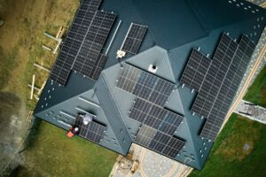 Men workers installing solar panels on roof of house.